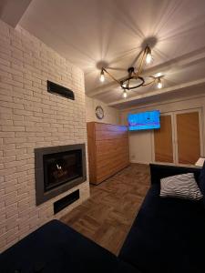 a living room with a brick wall and a fireplace at Pod Morskim Niebem in Poddąbie