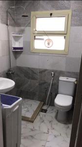 uma casa de banho com um WC, um lavatório e uma janela em New venecia resort em Ain Sokhna