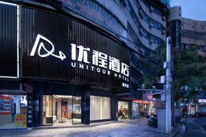 a store with a sign on the side of a building at Unitour Hotel, Xiangxiang Dongfeng Square in Xiangxiang