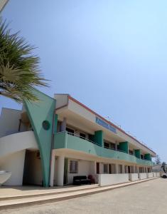 een gebouw met een palmboom ervoor bij Residence Fronte Mare in Santa Maria Del Focallo