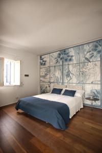 een slaapkamer met een groot bed en een grote muur bij Terrazzini Cibele in Andria