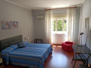 - une chambre avec un lit bleu et une fenêtre dans l'établissement B&B Maltese, à Palerme