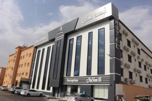 a building with cars parked in a parking lot at أبهى سكن للشقق المخدومة in Abha