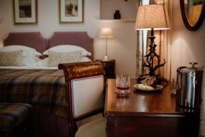 a bedroom with a bed and a desk with a lamp at Links House at Royal Dornoch in Dornoch