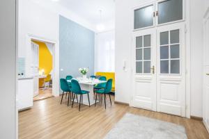 a dining room with a table and blue chairs at Cityscape Apartments Theresa in Budapest