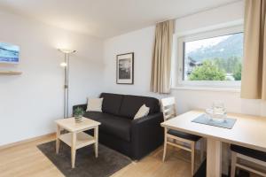 ein Wohnzimmer mit einem Sofa und einem Tisch in der Unterkunft Apartment Paula in Seefeld in Tirol