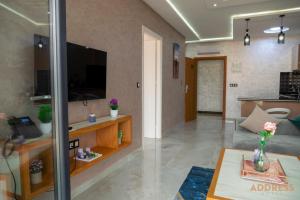 a living room with a couch and a tv at Bella Address Hotel Beach in Saïdia