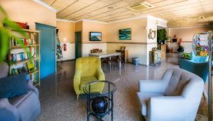Habitación con sofás, sillas y mesa. en Hotel Galicia en Fuengirola