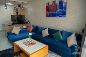 a living room with a blue couch and a table at Bella Address Hotel Beach in Saïdia