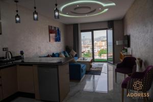 a kitchen and a living room with a couch at Bella Address Hotel Beach in Saïdia
