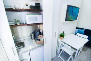 a small kitchen with a table and a microwave at SoBo Studio 2 - by Brighton Holiday Lets in Brighton & Hove