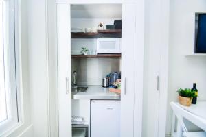 a kitchen with white cabinets and a microwave at SoBo Studio 2 - by Brighton Holiday Lets in Brighton & Hove