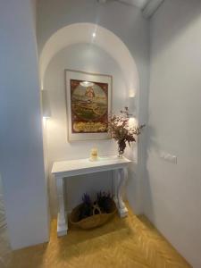a white table in a room with a picture on the wall at Doñana Suite Casa-Hotel in El Rocío
