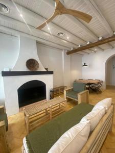 a living room with a fireplace and a ceiling fan at Doñana Suite Casa-Hotel in El Rocío