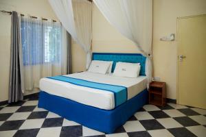 a bedroom with a blue bed with a checkered floor at Jacyjoka Apartments Nyali in Mombasa +71 photos