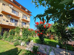 einen Garten vor einem Gebäude mit roten Blumen in der Unterkunft Casa Roua in Venus