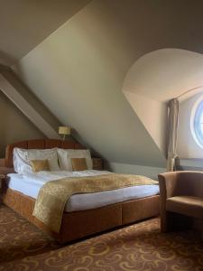 a bedroom with a bed and a window at Hotel Zlatá Včela in Domažlice