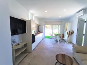 eine Küche und ein Wohnzimmer mit einem Sofa und einem Tisch in der Unterkunft Villas Florida in Conil de la Frontera
