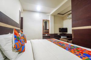 Un dormitorio con una cama con una manta de colores. en FabHotel Shravan, en Nagpur