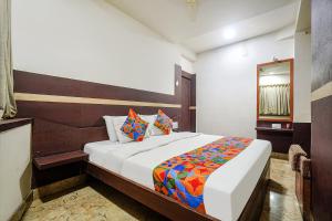 a bedroom with a bed and a mirror in it at FabHotel Shravan in Nagpur