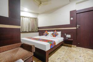 1 dormitorio con cama, puerta y silla en FabHotel Shravan, en Nagpur