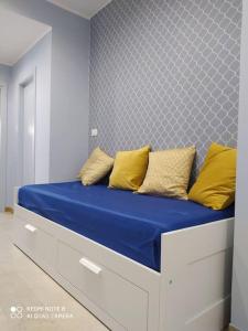 a bed with blue sheets and yellow pillows on it at Nuovi bilocali Panta Rei - Suite dell'Aria in Senigallia