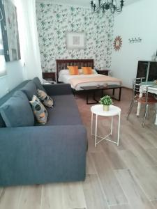 a living room with a blue couch and a bed at APARTAMENTO ABADIA in Málaga