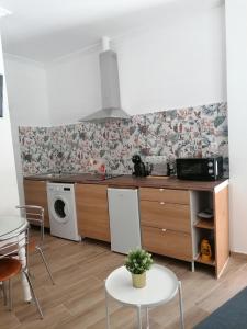 a kitchen with a stove and a table and a microwave at APARTAMENTO ABADIA in Málaga