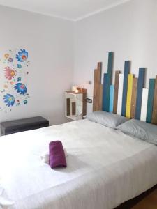 ein weißes Bett mit einem lila Handtuch darauf in der Unterkunft Maresme´s corner in Sant Andreu de Llavaneres