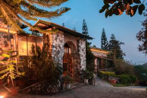 德拉敦Tree of Life Resort Dehradun Foothills的石头房子,有通往房子的路径