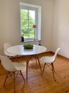 einen weißen Tisch und Stühle in einem Zimmer mit Fenster in der Unterkunft Landidylle auf dem Rittergut in Blomberg
