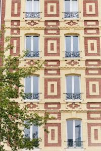 wysoki ceglany budynek z oknami i balkonami w obiekcie Smart Appart Le Havre 97 w Hawrze