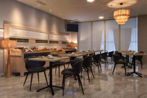 a restaurant with tables and chairs in a room at Hotel Castro Real in Oviedo