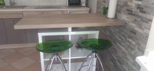 a kitchen with two green stools under a counter at Apartment Tuja in Jadrtovac