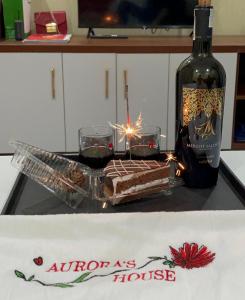 uma garrafa de vinho e um bolo de chocolate no balcão em Aurora's House em Dong Van