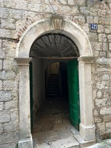 an archway in a stone building with a green door at Apartment Kotor Old Town in Kotor