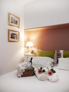 una camera da letto con un letto con asciugamani e un cesto di rose di Portico Cozy Home a Kariá