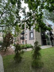 a park with a bench in front of a building at Birstonas Holidays Apartment in Birštonas