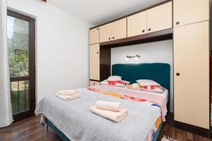 a bedroom with a large bed with towels on it at Apartman Kovač in Malinska