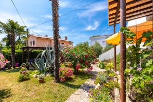 a garden with flowers and plants next to a building at Apartman Kovač in Malinska