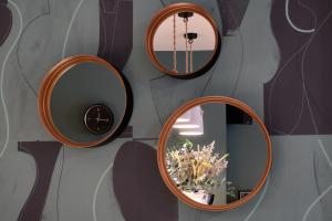 tres espejos redondos en una pared con un jarrón con flores en Hotel Castro Real, en Oviedo