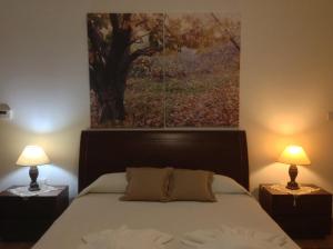 a bedroom with a bed with a painting on the wall at Ta Spitakia tis Theodosias in Kalopanayiotis