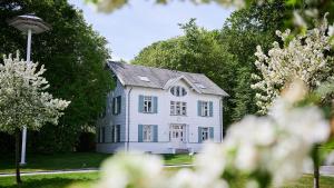 ein weißes Haus mit grauem Dach und Bäumen in der Unterkunft Grand Hotel Heiligendamm - The Leading Hotels of the World in Heiligendamm