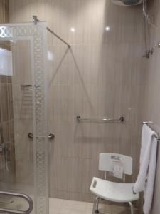uma casa de banho com um chuveiro e uma porta de vidro em شقق النرجس فيلا للشقق المخدومة em Riyadh