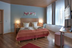 ein Schlafzimmer mit einem großen Bett mit einer roten Decke in der Unterkunft Schlossberghotel Oberhof in Oberhof