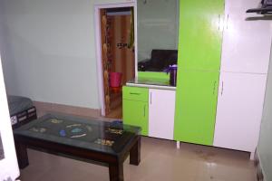 une cuisine avec des placards verts et blancs et une table dans l'établissement Hill View Guest House Bhaderwah, à Bhadarwāh