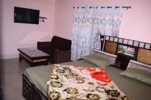 Cette chambre comprend un lit, un canapé et une télévision. dans l'établissement Hill View Guest House Bhaderwah, à Bhadarwāh