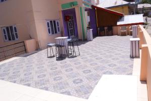 un patio avec des chaises et des tables ainsi qu'un bâtiment dans l'établissement Hill View Guest House Bhaderwah, à Bhadarwāh