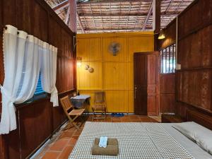 een kamer met een bed en een stoel. bij Ba Danh Homestay & Kitchen - Ben Tre Mekong in Ben Tre