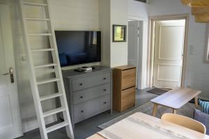 uma sala de estar com uma televisão e uma cómoda com uma escada em Mistral przy plaży Domki całoroczne em Ustka